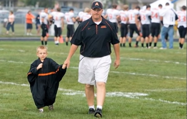 Jeremy Ferman, then the coach at Almont, accompanies Bryce across the field about a decade ago.
