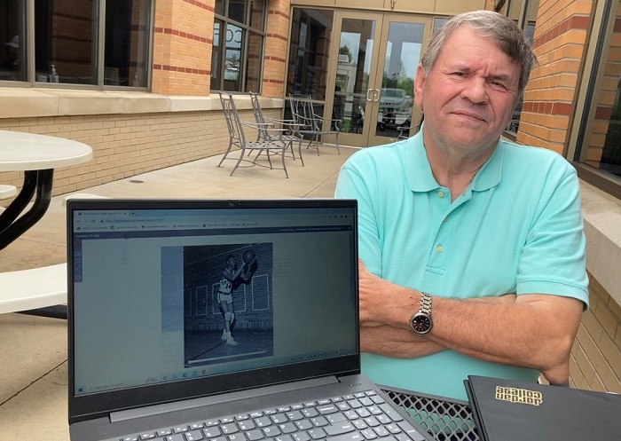 Long-time area coach Bob Sichtel examines hundreds of photographs that are part of the archives of the Grand Rapids Public Library. 