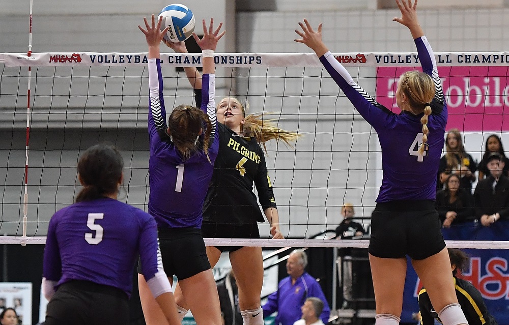 Lansing Christian’s Lydia Brogan (4) attempts to tip the ball over the net with Brubaker and Kylie Quist (1) defending. Quist led Athens with a match-high 11 kills, and Brubaker had a match-high 29 assists. The Pilgrims ended the season 30-12-1.