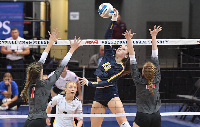 Cadillac’s Makenzie Johns (13) blasts a ball over the net as Dearborn Divine Child’s Reese Ringwelski (1) puts up a block. Johns had eight kills as Cadillac prevailed 16-25, 25-20, 25-21, 25-13.