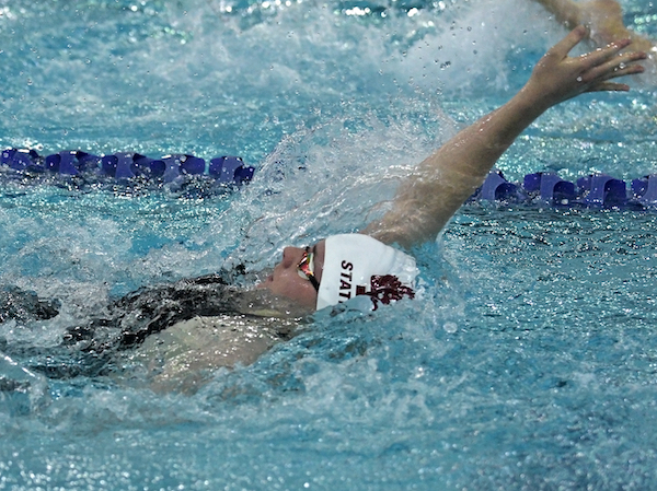 A Holland Christian swimmer competes in the backstroke.