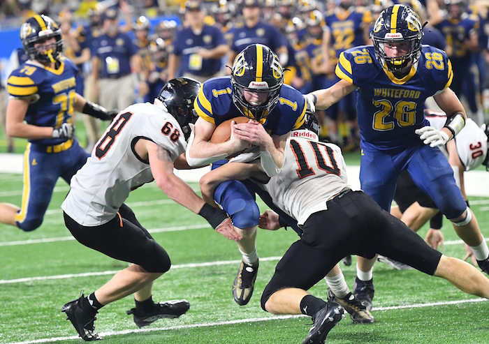 The Bobcats’ Shea Ruddy (1) pushes forward with Ubly’s Parker Peruski (68) and Evan Peruski (10) working to take him down. 