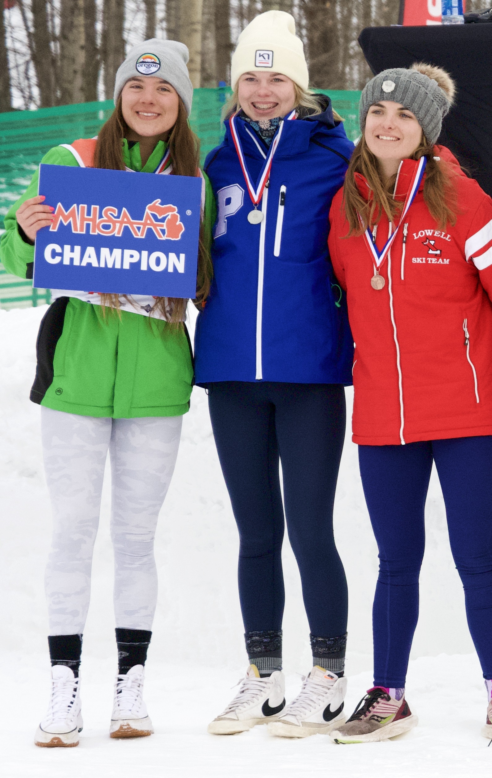  Schulte, far left and next to Petoskey’s Marley Spence and Lowell’s Kaylee Byrne, celebrates winning her second-straight slalom championship. 