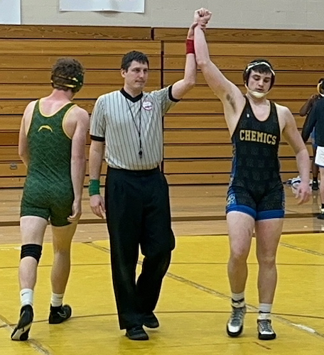 Wilson Shinske, far right, has his arm raised in victory after a match. 