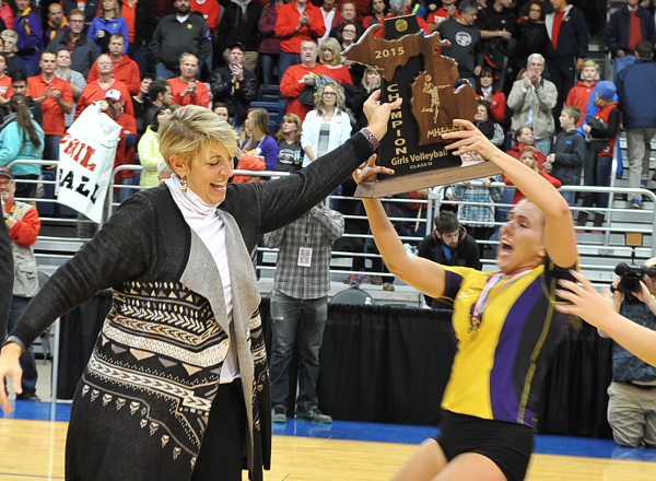 Glass passes the championship trophy to her team after the Comets won the 2015 Class D title.