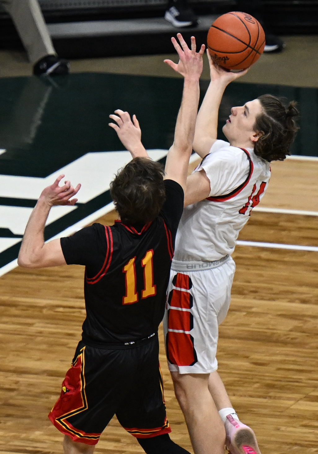 The Mustangs’ Cully Trzeciak (14) works to get up a shot over Ryan Trombley.