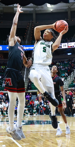 Cass Tech’s Darius Acuff (5) works to get a shot up over Muskegon’s Anthony Sydnor III.