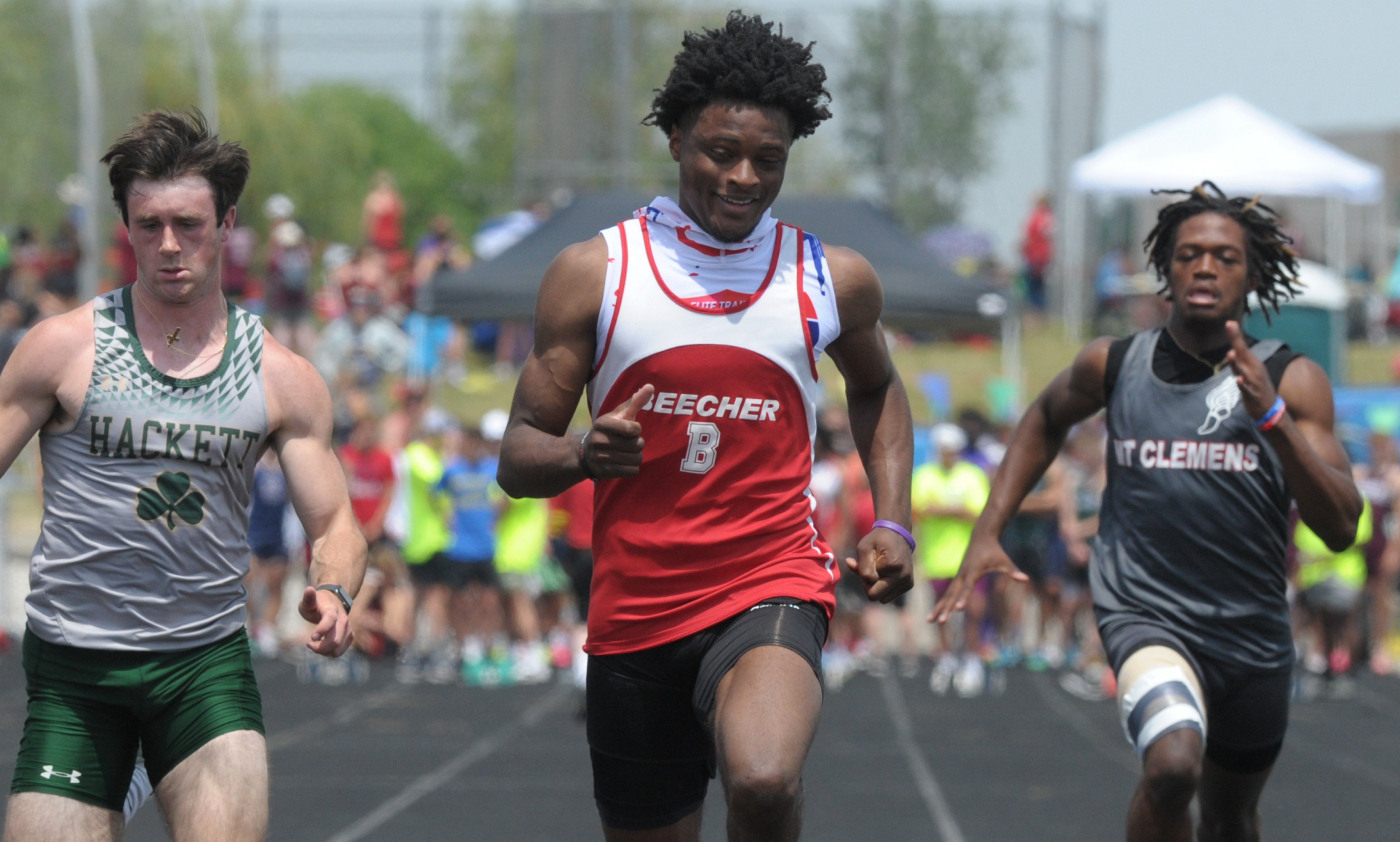 Flint Beecher's Jaylin Townsend, middle, crosses the finish first for one of his two sprint championships. 