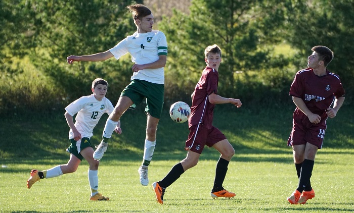 Harrington and Alex Moore (12) work to control possession against Charlevoix this season. 