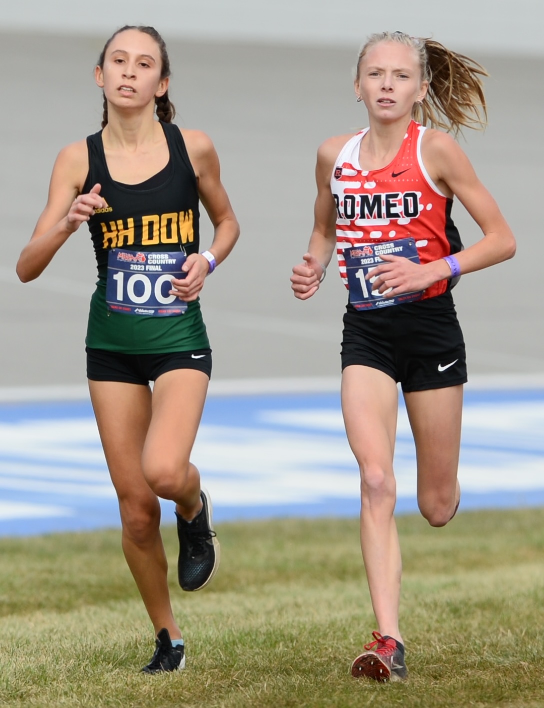 Midland Dow's Victoria Garces (200) and Romeo's Annie Hrabovsky run side-by-side down the closing stretch. 
