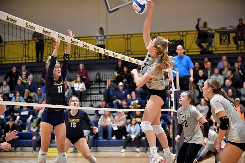 Clarkston's Rylee Hunt (11) prepares to put up a block at Macomb L'Anse Creuse North's Kate Schneider connects during their Division 1 Quarterfinal. 