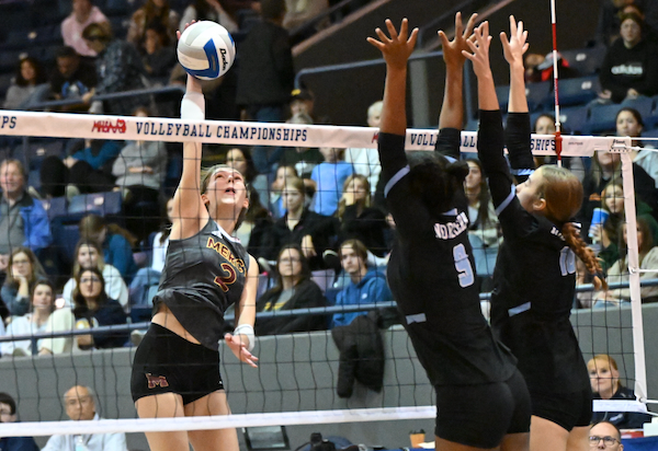 The Marlins’ Kate Kalczynski (2) connects on a kill attempt with Kendall Hopewell (9) and Riley Loehfelm (16) putting up a block.