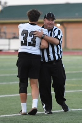South Lyon East's Dante DeGrazia (33) and official Chris Curtis meet for a quick hug during East's Week 5 game.