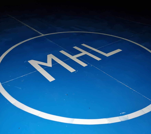 The daughters’ initials “MHL” glow on the court the family funded in Macedonia.