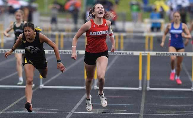 Addison's Molly Brown, right, finishes her 100 hurdles championship win.