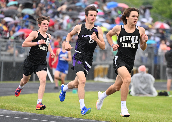 During a rainy 1,600, Munising's Dan Goss (1) leads the race with Pickford's Hayden Hagen (2) and Munising's Trevor Nolan (3) right behind him. 