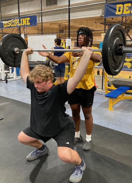 Cardale Winebrenner (standing) spots for teammate Trapper Reigler; both are captains this fall. 