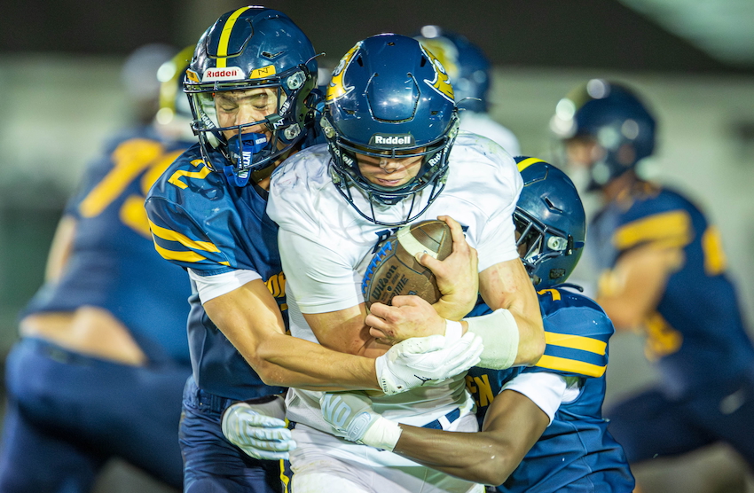 A pair of North Muskegon defenders wrap up a Pewamo-Westphalia ball carrier.