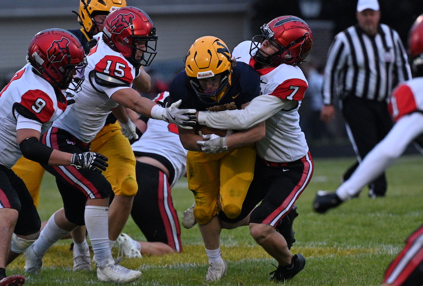Negaunee's Marshall Peters carries the ball before getting tackled by Marquette's Ben Rayhorn (7), Bodi Bennett (15), and Alex Brennen (9).