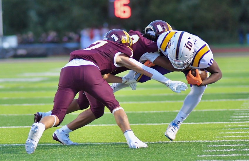 A pair of Davison defenders wrap up a De La Salle ball carrier.