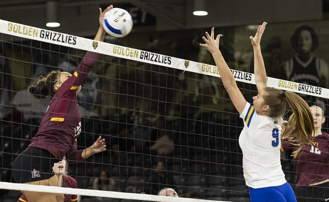 Farmington Hills Mercy’s Cydnee Speights (39) elevates above the net as Bloomfield Hills Marian’s Cecilia Murray goes for the block during the CHSL Cardinal championship match.