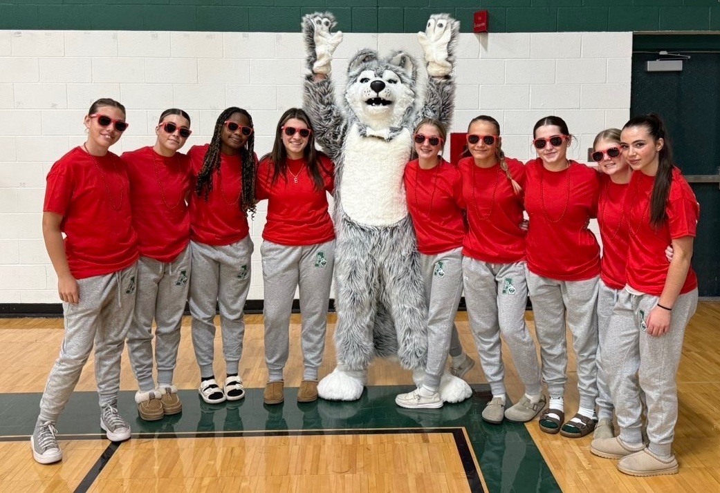 The Huskies enjoy a moment with their mascot.