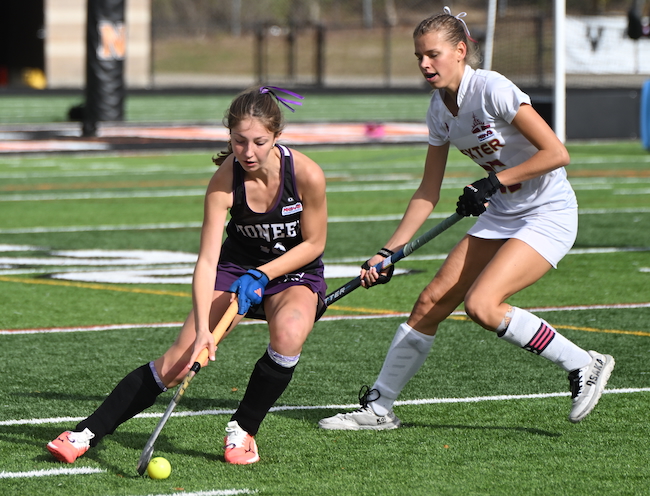 Pioneer's Violet Soldan (10) connects while Dexter's Claire Dubuque defending.