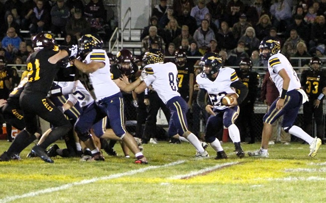 Sam Schneider (22) carries the ball and follows his Chiefs blockers as they attempt to create an opening against the Eagles.