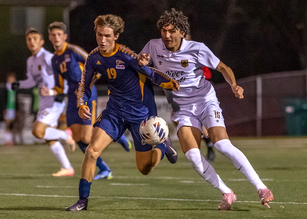 Central’s Eli Greenwald (19) and Huron’s Malic Kasham compete for a loose ball.