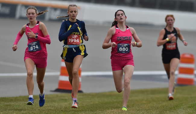 Lansing Catholic's Josie Bishop (874) and Grace Wonch (880) and Roscommon's Alaina Civinskas (1194) surge toward the finish line. 