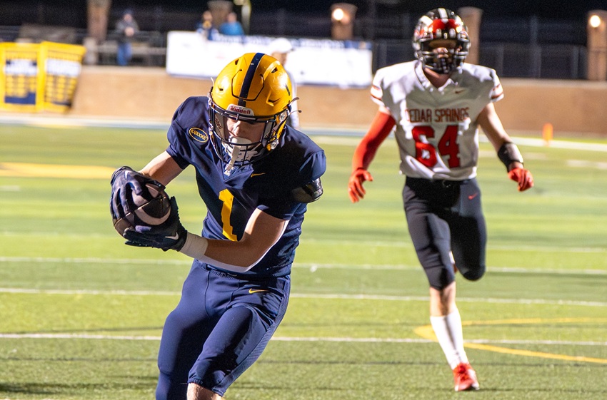East Grand Rapids' Tyler Blake (1) reaches the end zone as a Cedar Springs defender pursues during the Pioneers' 23-21 victory.