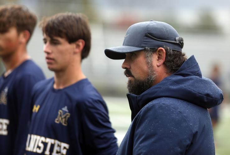 Manistee coach Brandon Prince, far right, talks to his team. Scharp is to his immediate right. 