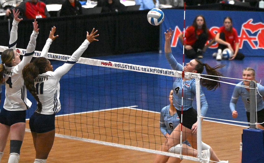 Grand Rapids Christian junior Taylor Frost (4) sends a kill attempt toward a block by Country Day sophomore Sici Guerrant (11) and junior Leah Green. 
