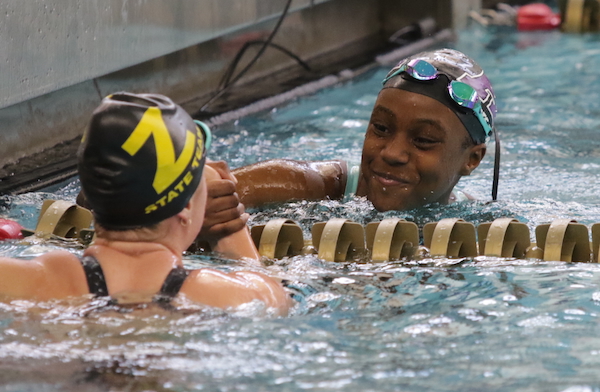 Pioneer’s Kia Alert, right, and Zeeland’s Madison Ensing share a moment after finishing first and second, respectively, in the 50 freestyle.