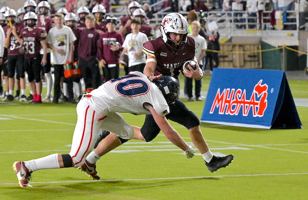 The Mustangs’ Noah Carlson (10) attempts to slow down Haylen Buell as he approaches the end zone.
