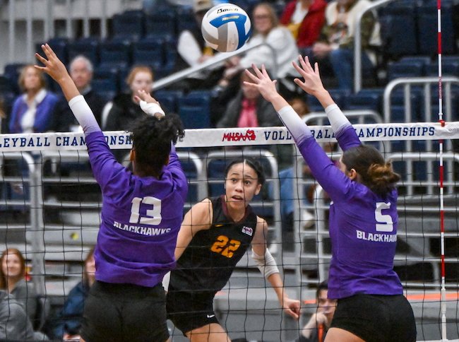 Mercy’s Cree Hollier (22) attempts a kill as Bloomfield Hills’ Suri Ewing (13) and Charlotte Elowsky elevate to try and block it.