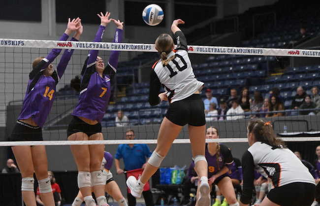Kingsley’s Aizlyn McKinley sends a kill attempt toward the net and Kalamazoo Christian blockers Ashlyn Triemstra (14) and Lydia Boley (7).