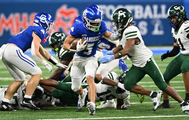 The Shamrocks’ Samson Gash (5) attempts to put space between himself and a Cass Tech defender. 