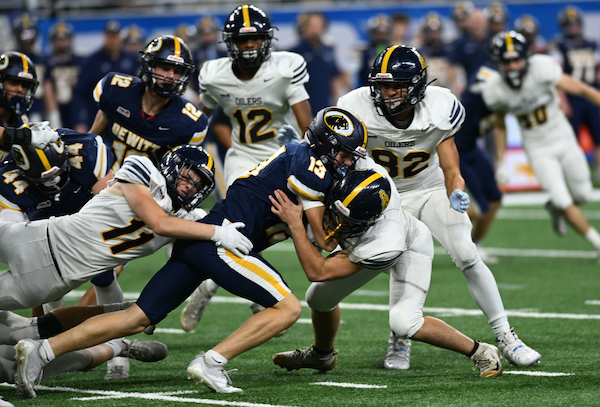 Landon Kurncz (13) attempts to surge ahead with Mount Pleasant’s Keagan Wernette-Beals (11) and another defender wrapping him up.