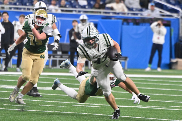 Collin Abram (43) attempts to get out of the grasp of a Notre Dame Prep defender.