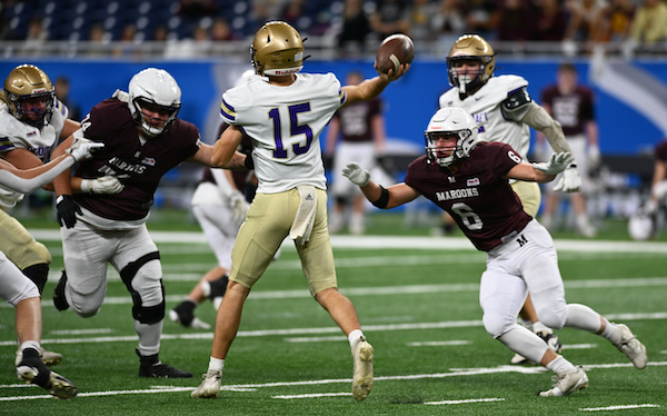 The Maroons’ Jackson Myszak (6) puts pressure on Schoolcraft quarterback Jack DeVries.