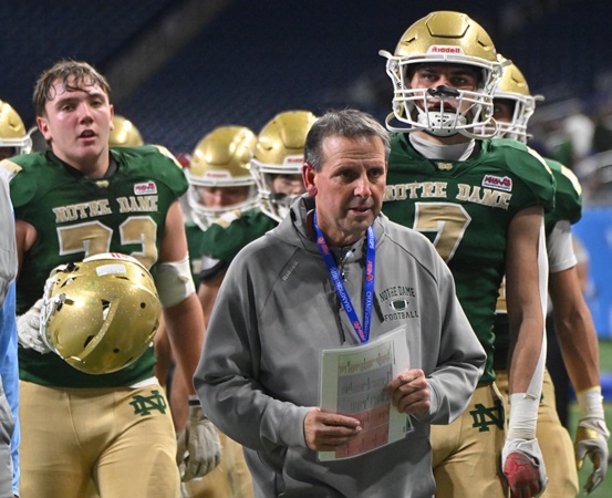 Fighting Irish coach Pat Fox leads his team – including Henry Ewles (72) and Brody Sink (7) – off the field.