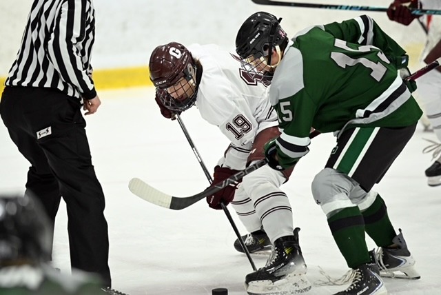 Luke DeBoer (19) takes a faceoff against Jenison.