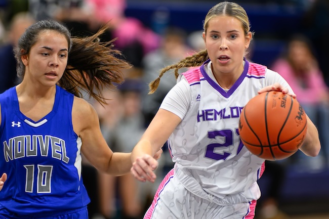 Hemlock senior guard Victoria Hauffe (21) drives through the Saginaw Nouvel Catholic Central defense during the first quarter Friday. 