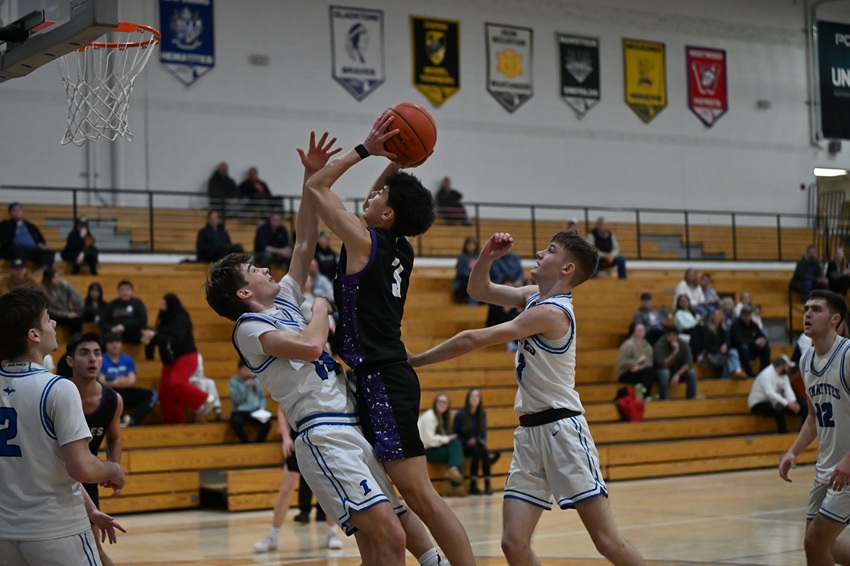 Gladstone's Lonnie Davey puts up a shot while defended by Ishpeming's Dax Kakkuri (14) and Kenny Ambuehl (3) on Jan. 20.