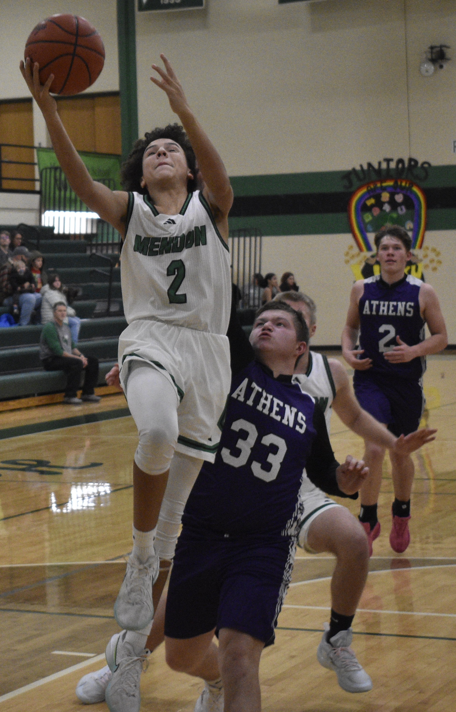 Mendon junior guard Kyron Truckey (2) drives inside for a layup and scores against Athens. 