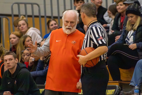 Veteran coach Dan George talks with a game official. 