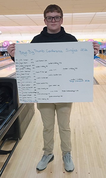  Zander Lindsley holds up the bracket after winning the Big Thumb Conference boys singles championship Jan. 31. 