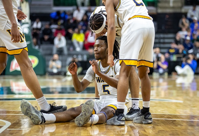 Teammates help Allen up from the floor during the Zebras’ Semifinal win.