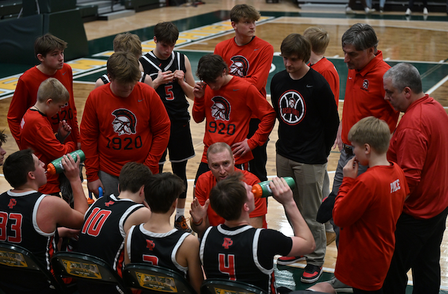 Trojans coach Jason Price talks to his team between the third and fourth quarters against Marquette. 